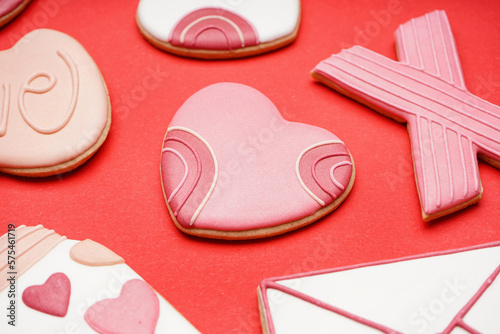 Different sweet cookies for Valentine's Day celebration on red background, closeup