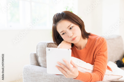 Free Download 部屋でタブレットを見る女性　考える - GFXLoad