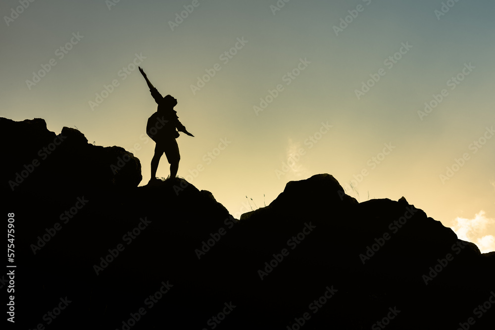 Hiker with arms up standing on the top of the mountain - Successful man enjoying triumph - Sport and success concept
