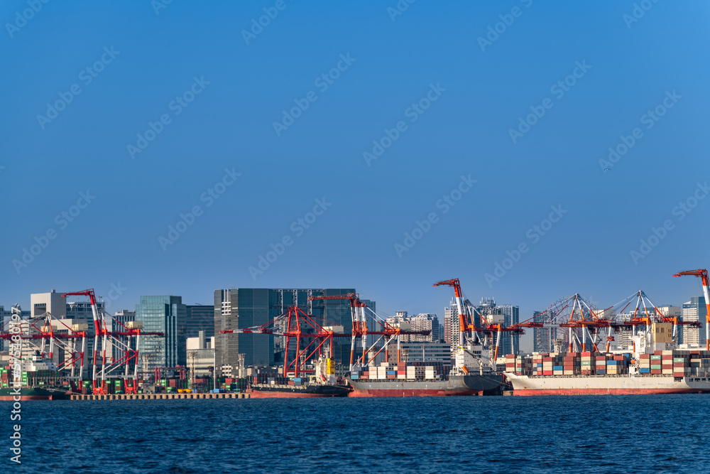 東京湾のコンテナ貨物船とガントリークレーン