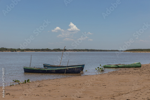 Three canoes moored on the river bank.