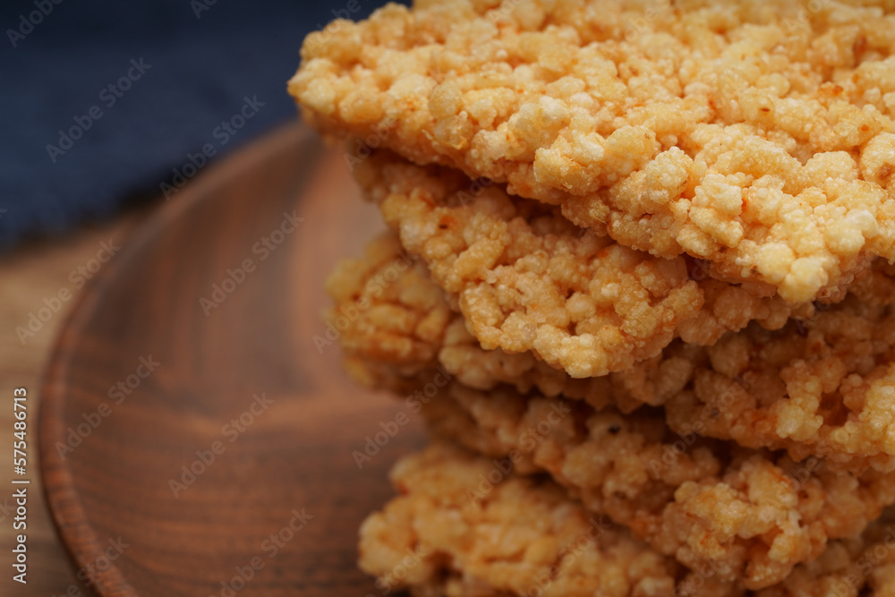 A plate of crispy rice is on the wooden table A plate of crispy rice is on the wooden table