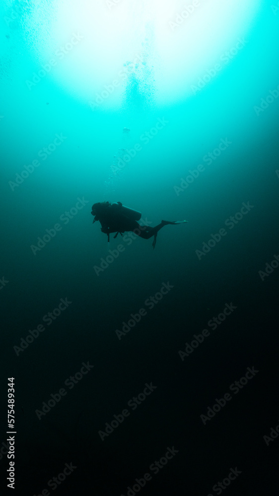 silhouette of a diver in angelita cenote, unrecognizable person
