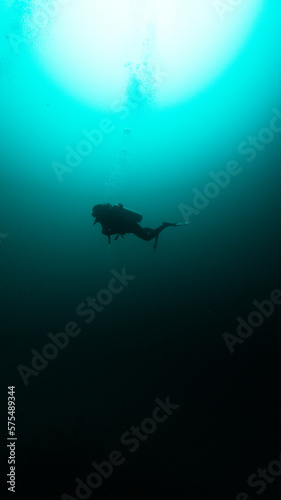 Fototapeta Naklejka Na Ścianę i Meble -  silhouette of a diver in angelita cenote, unrecognizable person