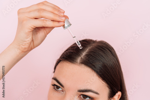 Lady drops a pipette into her head parting.