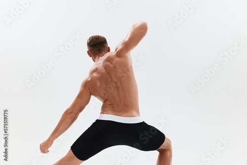 Man athletic body bodybuilder in briefs with naked torso abs full-length in the background, fitness classes. Advertising, sports, active lifestyle, competition, challenge concept.