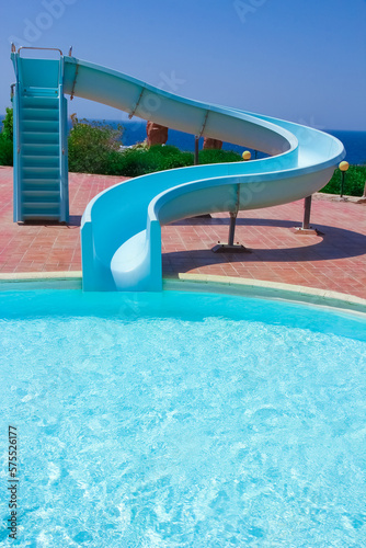 Fotografie Stylishly interesting water slide in the pool near the sea on nature background