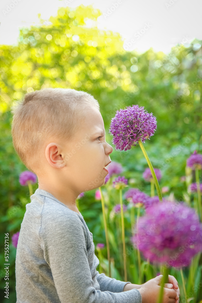 Happy child with flowers sniffing in the park on nature travel Happy child with flowers sniffing in the park on nature travel