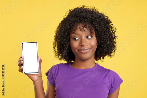 Curious afro woman looking to a blank mobile screen