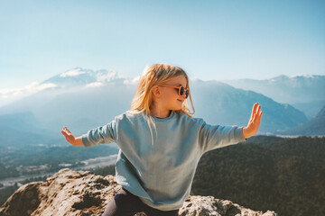 Child traveling in mountains raised hands hiking family healthy lifestyle active summer vacations outdoor 4 years old girl enjoying view