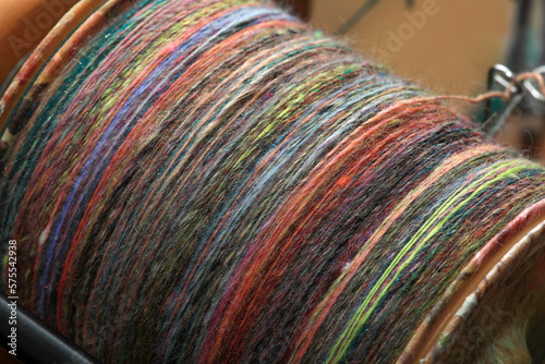 Closeup detail of colourful organic natural handspun and handdyed merino sheep wool yarn , spun on a traditional spinning wheel photo