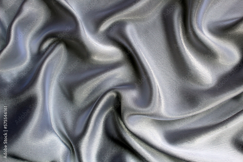 Fototapeta premium Gray satin fabric lies drapery, top view.