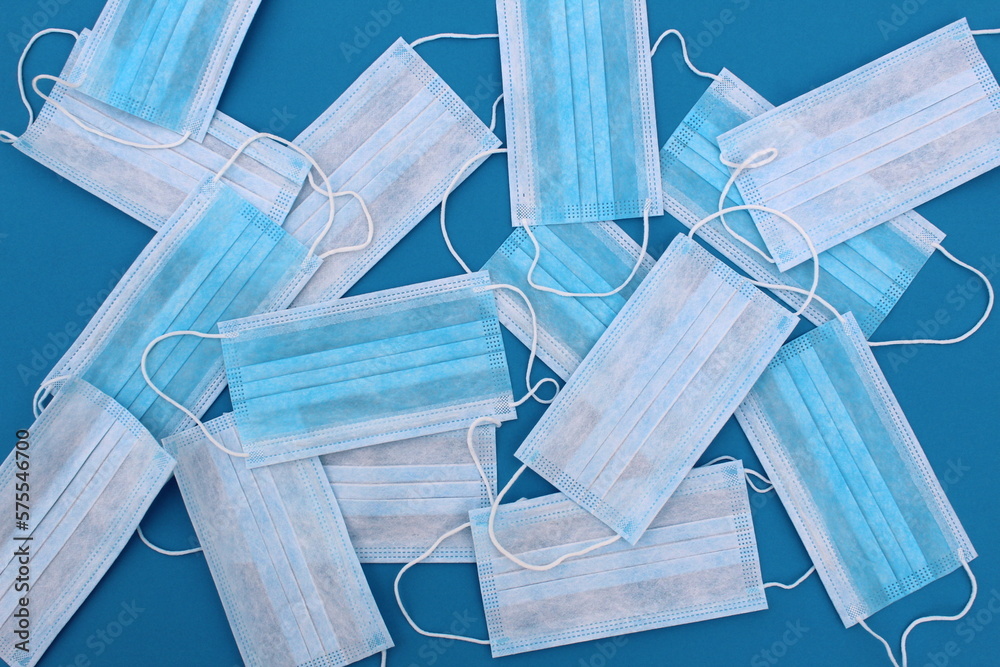 A lot of blue sterile medical masks lie in a pile. A lot of blue sterile medical masks lie in a pile.
