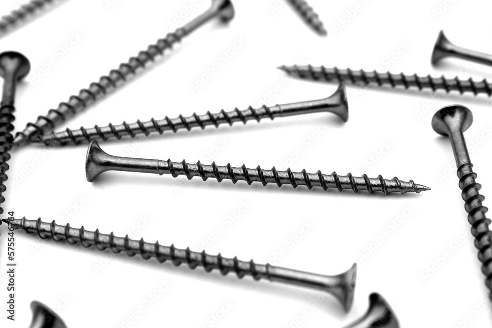 A lot of self-tapping screws lie on a white isolated background.	