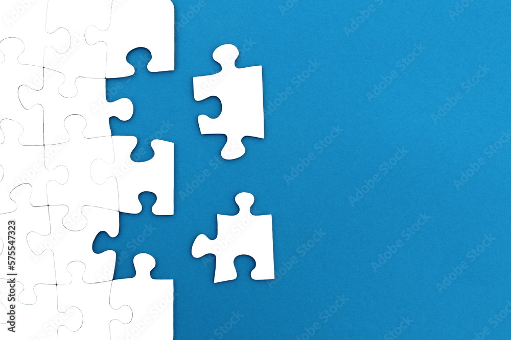 The game, a lot of white puzzle pieces lie on a blue background. The game, a lot of white puzzle pieces lie on a blue background.