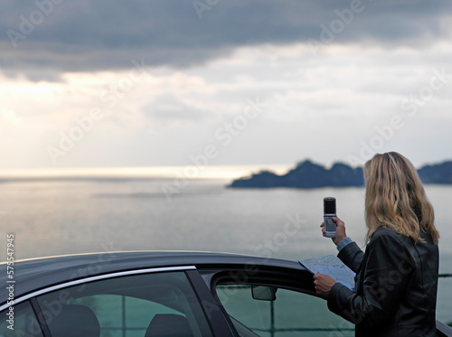 Woman takes photo with cell phone of calm sea photo
