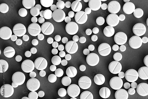 White pills lie on a gray background.Texture.