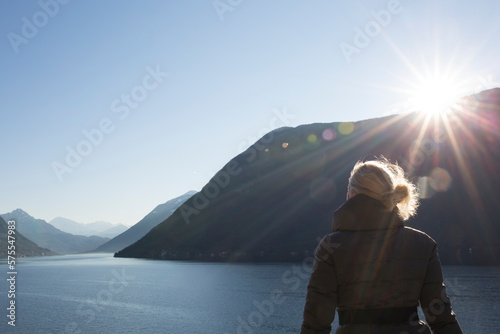 Mature woman looks out over lake and mountains photo