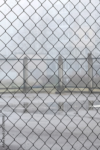 Fence net against backdrop of playground for games in fog