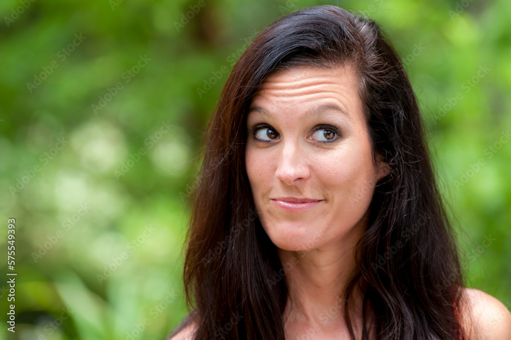 A 38 year old brunette woman outdoors making a face looking away from the camera. A 38 year old brunette woman outdoors making a face looking away from the camera.