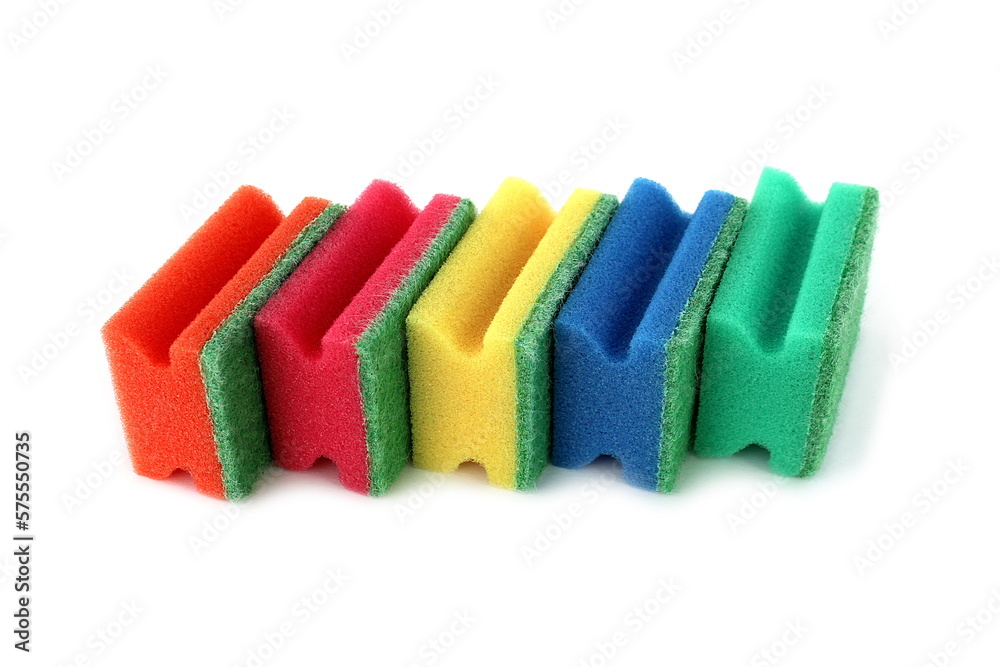 Many bright multi-colored sponges for washing dishes lie on a white background.	
