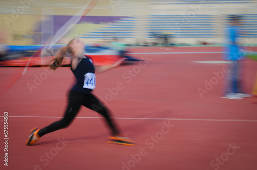 Unrecognized athlete doing javelin  spear throw in a sport competition. Javelin thrower at stadium photo