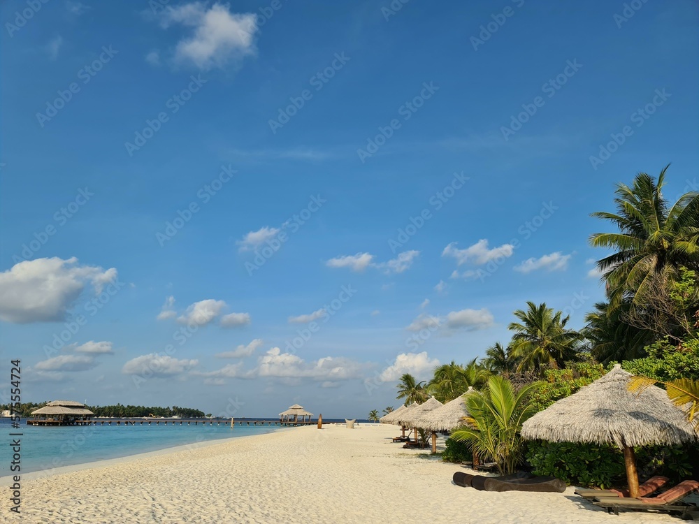 Maldivian island, Kihaa Maldives. Beach with golden sand, bungalows and palms