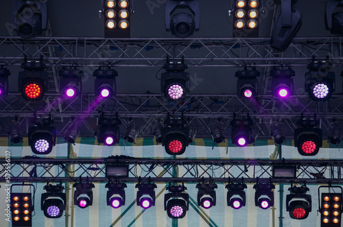 Concert lighting mounted on rack above the stage. High bar with professional LED spotlights and flood light projectors