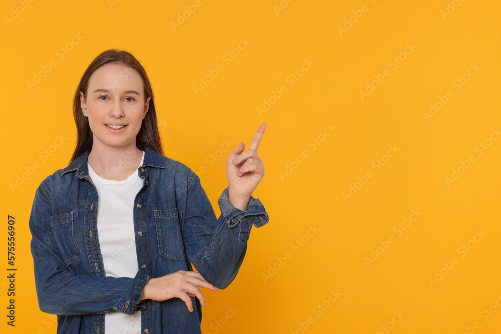 Portrait of teenage girl on orange background. Space for text Portrait of teenage girl on orange background. Space for text