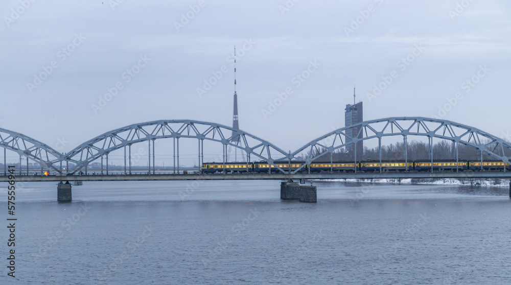 Naklejka premium A railway bridge over a river with a moving train