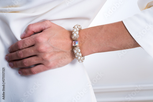 Woman`s hand with jewelry, white clothes