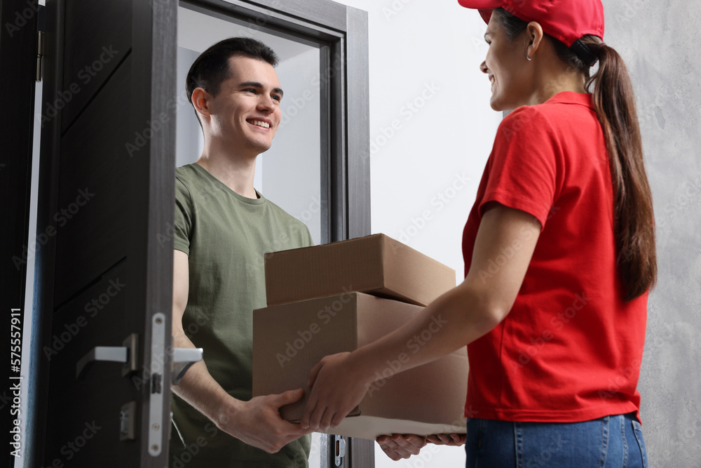 Obraz premium Courier giving parcels to man at house entrance