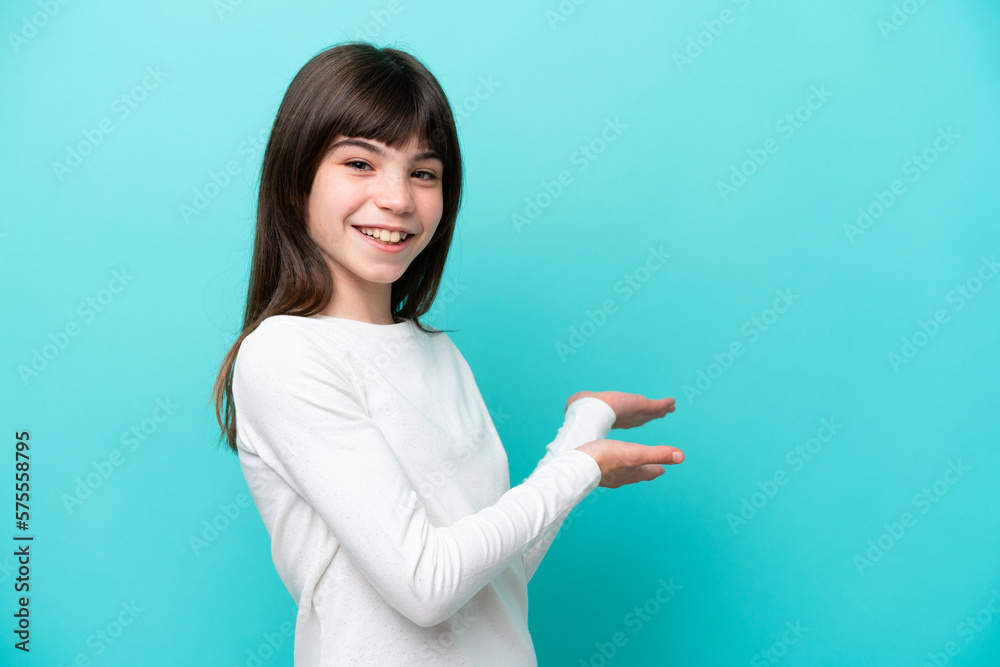 Little caucasian girl isolated on blue background extending hands to the side for inviting to come Little caucasian girl isolated on blue background extending hands to the side for inviting to come