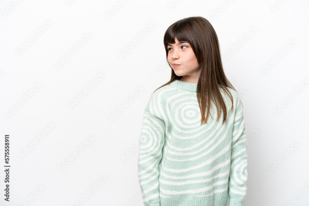 Little caucasian girl isolated on white background having doubts while looking side Little caucasian girl isolated on white background having doubts while looking side