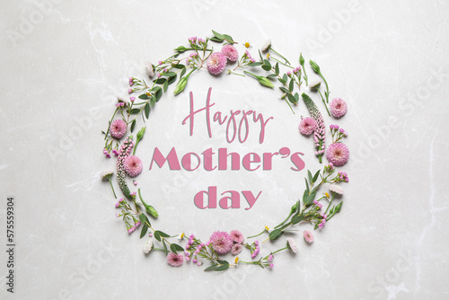 Happy Mother's Day. Greeting card with frame of pink flowers on light background, top view