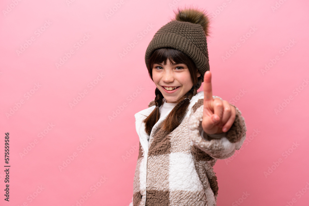 Little caucasian girl with winter jacket isolated on pink background showing and lifting a finger Little caucasian girl with winter jacket isolated on pink background showing and lifting a finger