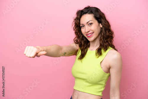 Young caucasian woman isolated on pink background giving a thumbs up gesture