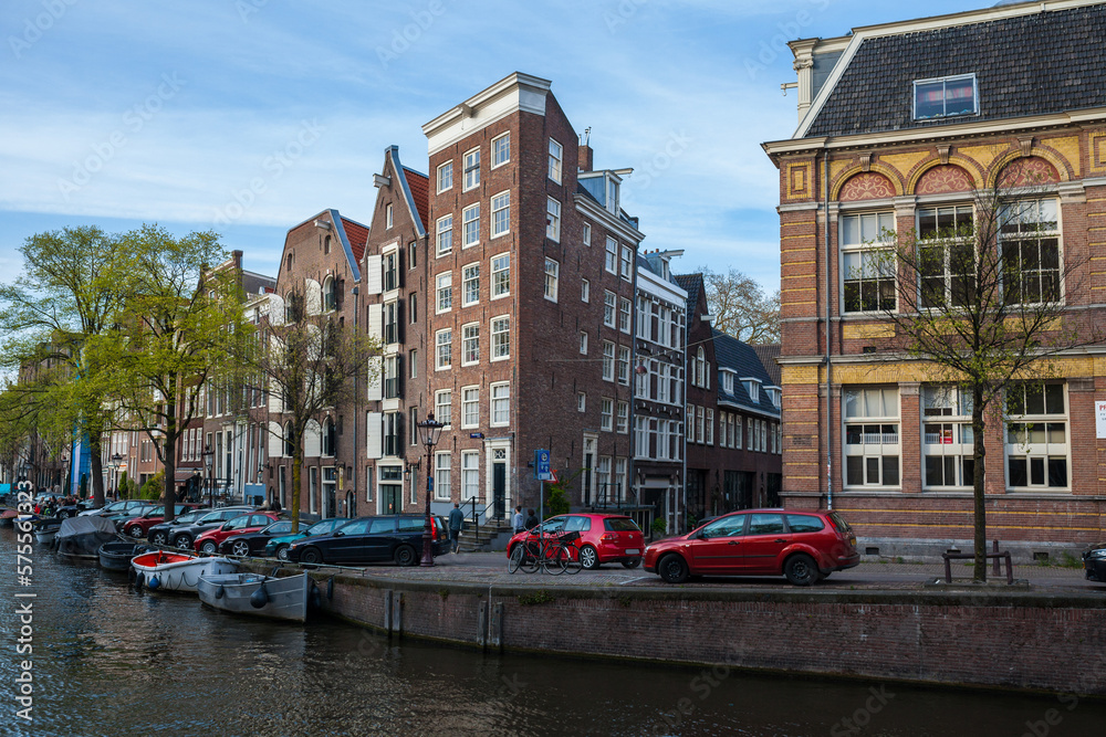 Colorful houses and cars along the canal embankment in Amsterdam, Netherlands
