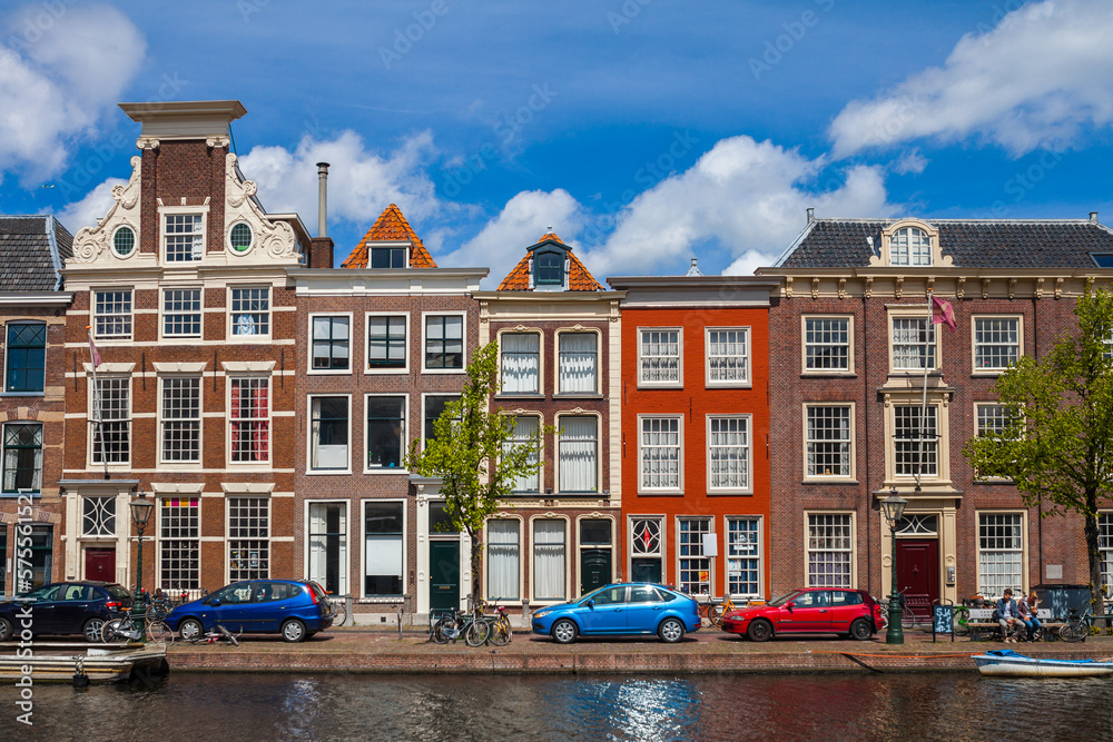Colorful houses and cars along the canal embankment in Leiden, Netherlands