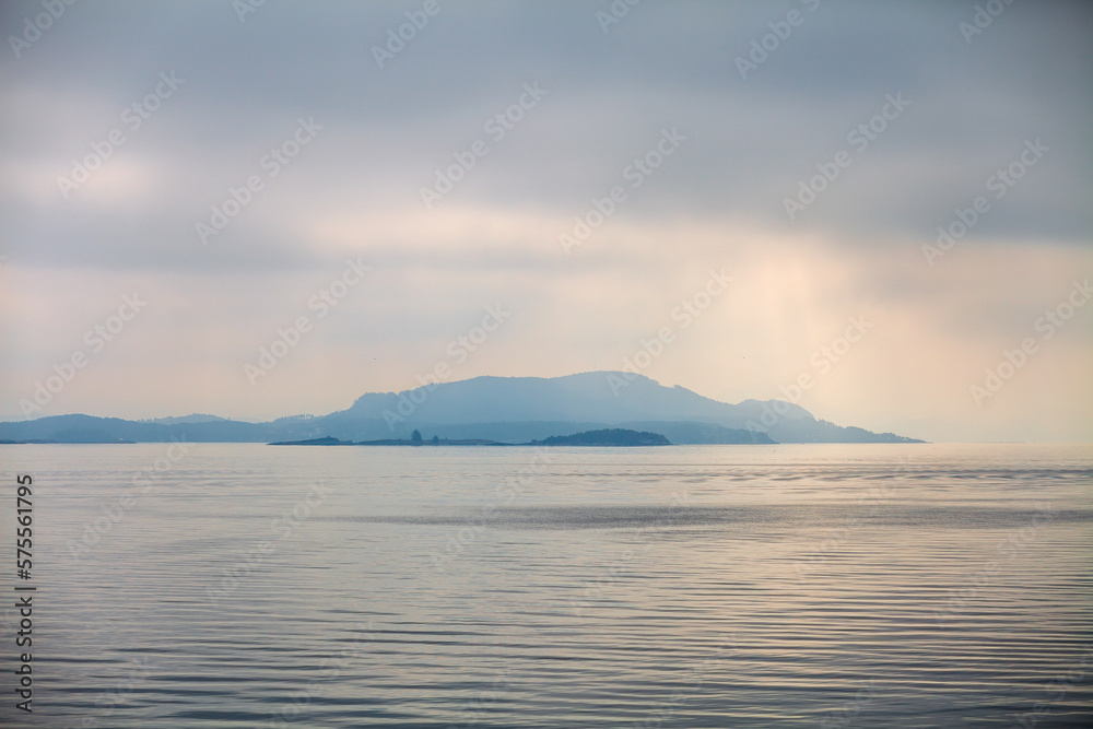 Tranquility in Norway. Misty islands during the overcast day near Stavanger