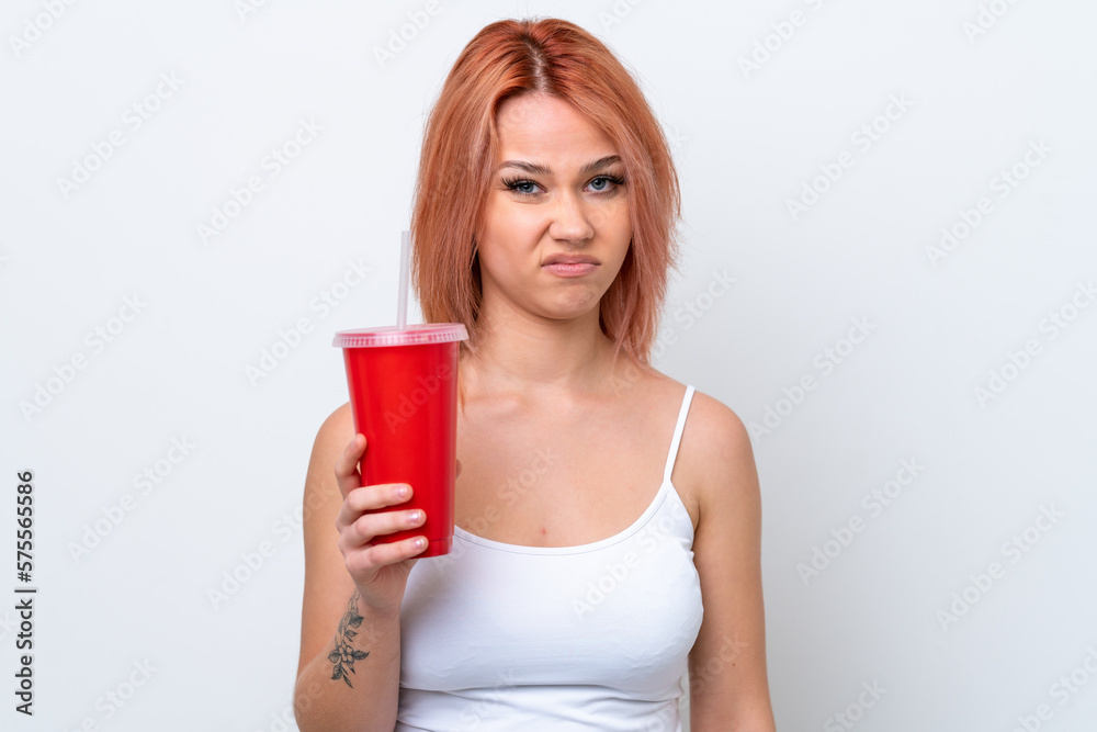 Young Russian woman holding soft drink isolated on white background with sad expression Young Russian woman holding soft drink isolated on white background with sad expression