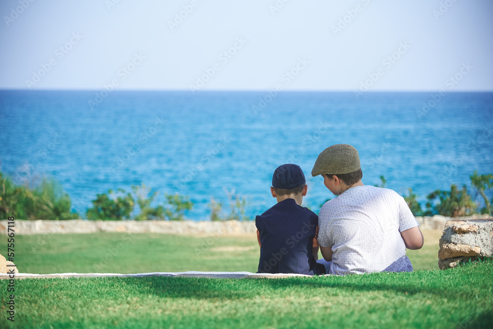 two children sitting and talking with sea view and garden view
