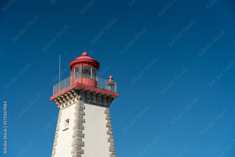 Top of an old red and white lighthouse under a sunny blue sky in Southern France, Leucate. 