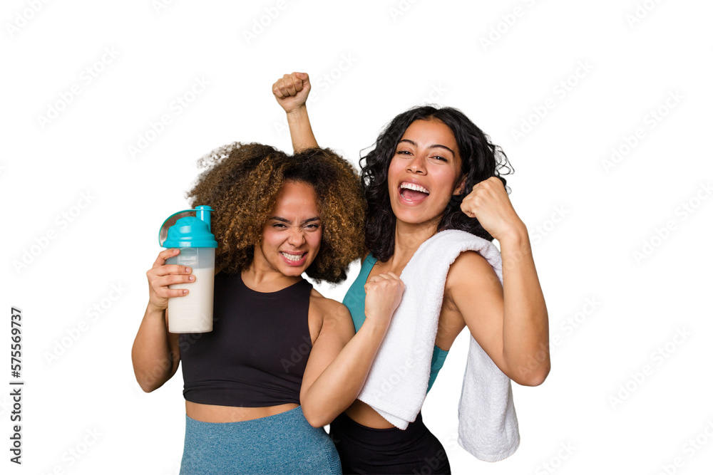 Two best friends are ready to go to the gym, one of them holds a protein shake, raising fist after a victory, winner concept. - obrazy, fototapety, plakaty 