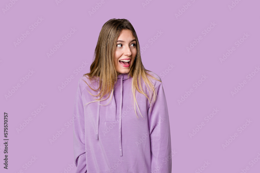 Young blonde posing for a portrait isolated, exuding natural beauty and radiance laughs and closes eyes, feels relaxed and happy. Young blonde posing for a portrait isolated, exuding natural beauty and radiance laughs and closes eyes, feels relaxed and happy.