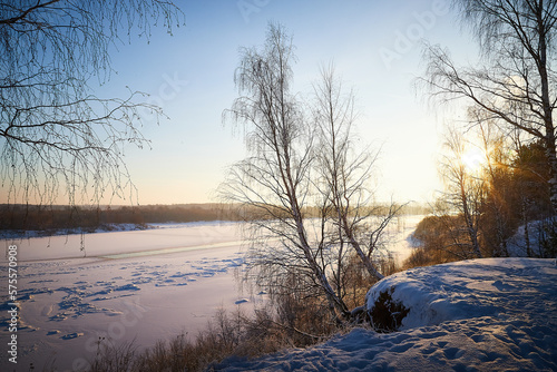 Sunrise on winter morning and trees with bare branches on a cold sunny time and snow on field © keleny