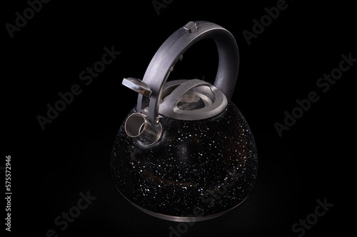 Stainless steel stovetop kettle with steam whistle on black background