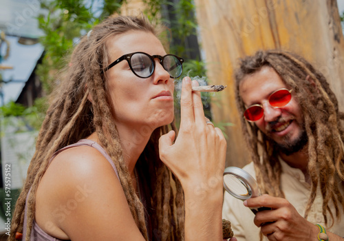 Hippie style couple smoking cigarettes with medical marijuana