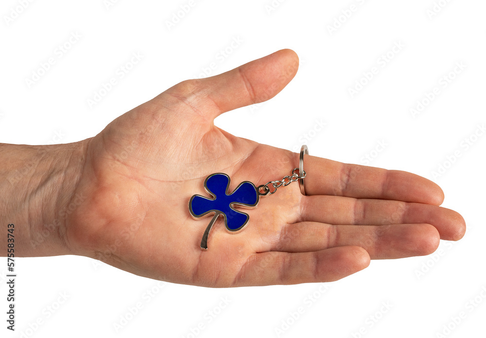 Hand holding shamrock, blue leaf shaped trinket isolated on white background Hand holding shamrock, blue leaf shaped trinket isolated on white background