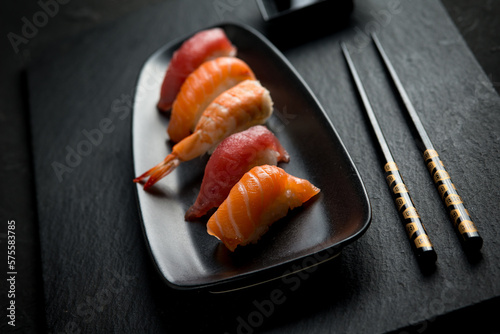 sushi with chopstick over black stone